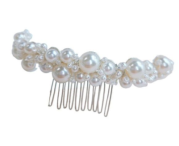 A silver-colored metal hair comb adorned with a cluster of white pearls of varying sizes, arranged in a floral-like pattern.