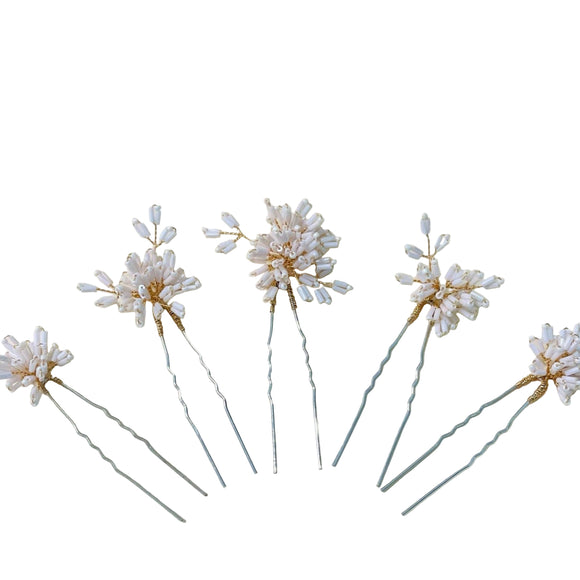 A set of five light pink floral hair pins with gold wiring on a white background.