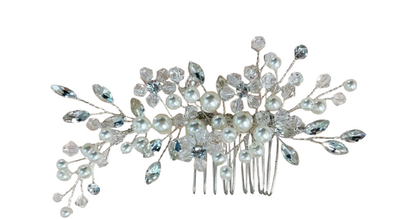 Elegant hair comb with pearls and crystals on a light background
