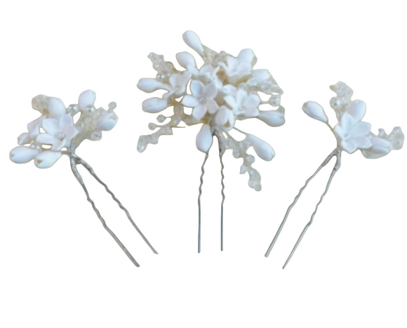 Three white floral hairpins on a white background